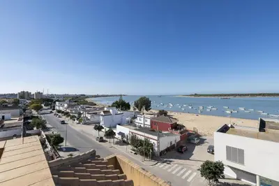 a city with a beach and boats in the water at Atico Costa Doñana in Bonanza
