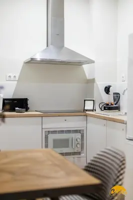 a kitchen with a microwave and a wooden table at Writer's Home by Cadiz Time in Cádiz
