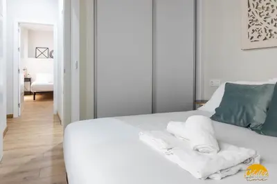 a bedroom with a white bed with towels on it at Writer's Home by Cadiz Time in Cádiz
