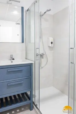 a bathroom with a shower with a blue cabinet and a sink at Writer's Home by Cadiz Time in Cádiz