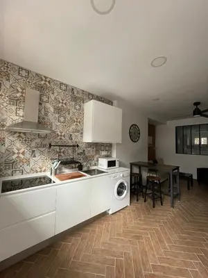 a kitchen with white cabinets and a table in it at Piso Céntrico perfecto para hospedarse in El Puerto de Santa María