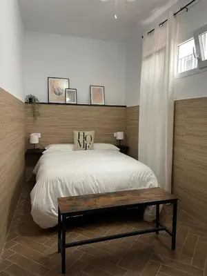 a bedroom with a large bed and a table at Piso Céntrico perfecto para hospedarse in El Puerto de Santa María