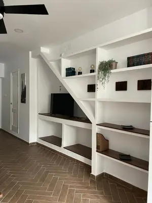 a living room with white shelves and a tv at Piso Céntrico perfecto para hospedarse in El Puerto de Santa María