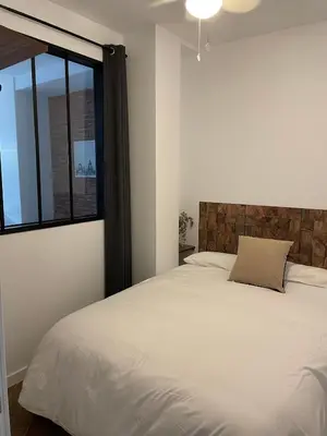 a bedroom with a white bed and a window at Piso Céntrico perfecto para hospedarse in El Puerto de Santa María