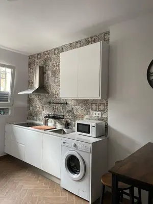 a kitchen with a washing machine and a microwave at Piso Céntrico perfecto para hospedarse in El Puerto de Santa María