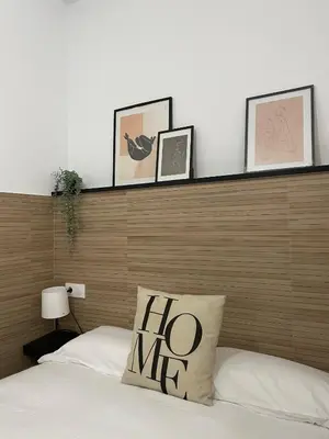 a bed with a wooden headboard with pictures on it at Piso Céntrico perfecto para hospedarse in El Puerto de Santa María
