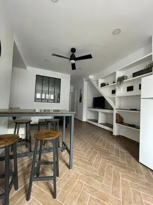 a dining room with a table and stools at Piso Céntrico perfecto para hospedarse in El Puerto de Santa María