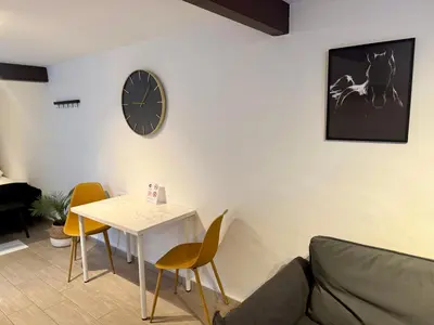 a living room with a table and a clock on the wall at La Faraona in Jerez de la Frontera