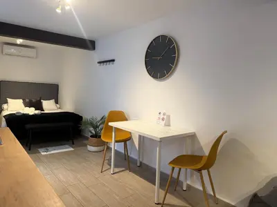 a living room with a table and a clock on the wall at La Faraona in Jerez de la Frontera