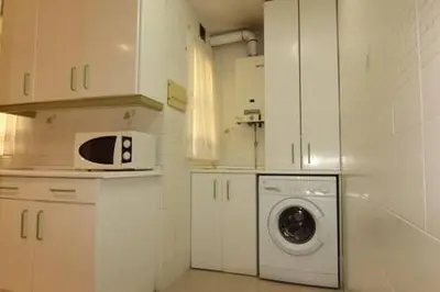 a kitchen with a washing machine and a microwave at Apartamento Paola in El Puerto de Santa María