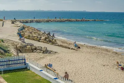 a group of people on a beach near the ocean at Apartamento Paola in El Puerto de Santa María