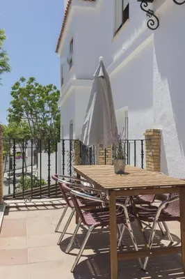a wooden table and chairs with an umbrella on a balcony at Playa de Regla, para un magnifico descanso. 3. in Chipiona