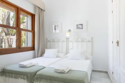 two beds in a bedroom with white walls and a window at Playa de Regla, para un magnifico descanso. 3. in Chipiona