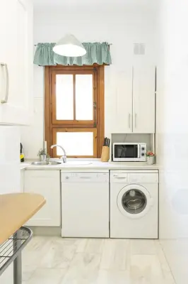 a kitchen with a washing machine and a microwave at Playa de Regla, para un magnifico descanso. 3. in Chipiona