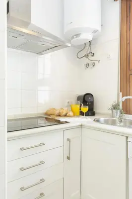 a white kitchen with white cabinets and a sink at Playa de Regla, para un magnifico descanso. 3. in Chipiona