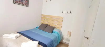 a bedroom with a bed with blue sheets and pillows at Apartamento TomCar Piscina, Pádel, wifi y zonas comunes in Sanlúcar de Barrameda