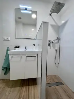 a white bathroom with a sink and a mirror at GATU Villa Paraguay in Cádiz