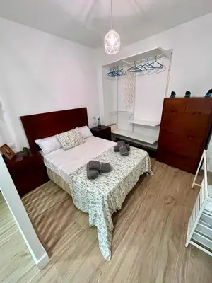 a bedroom with a bed and a dresser with shoes on it at GATU Villa Paraguay in Cádiz