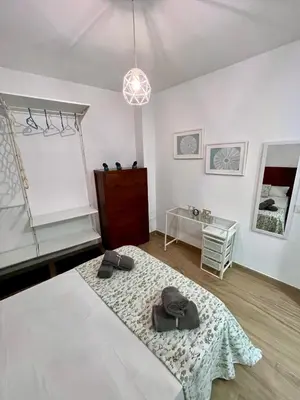 a room with a table and two shoes on a rug at GATU Villa Paraguay in Cádiz