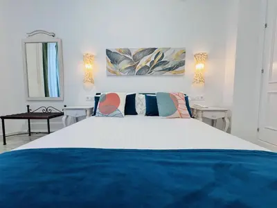 a bedroom with a large bed and a mirror at Hotel Boutique Las Cortes De Cádiz in Cádiz