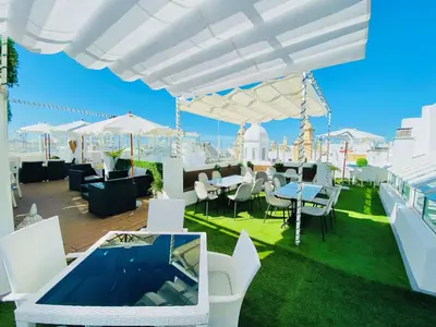 a patio with tables and chairs on a roof at Hotel Boutique Las Cortes De Cádiz in Cádiz