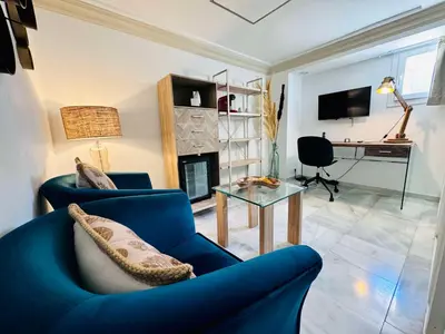 a living room with a blue couch and a fireplace at Hotel Boutique Las Cortes De Cádiz in Cádiz