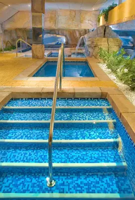 a swimming pool in a cave with blue water at Senator Cádiz in Cádiz