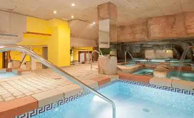a large swimming pool in a stone wall at Senator Cádiz in Cádiz