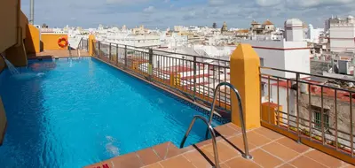 a table with two drinks and snacks on a balcony at Senator Cádiz in Cádiz