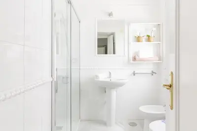 a white bathroom with a sink and a shower at Apartamento independiente en Playa de Regla. in Chipiona