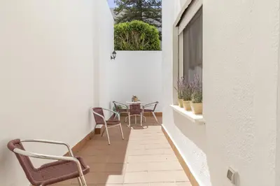 a small balcony with chairs and a table on it at Apartamento independiente en Playa de Regla. in Chipiona