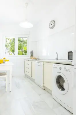 a white kitchen with a washer and dryer at Apartamento independiente en Playa de Regla. in Chipiona