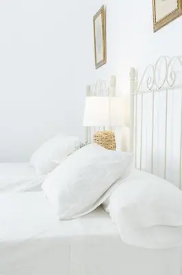 a white bedroom with white pillows on a bed at Apartamento independiente en Playa de Regla. in Chipiona