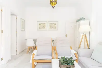 a living room with two chairs and a couch at Amplio apartamento en Playa de Regla. 2. in Chipiona