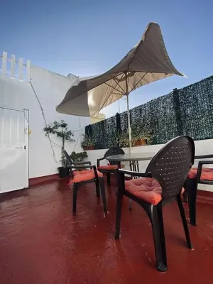 a patio with tables and chairs and an umbrella at Penthouse in the center in Cádiz