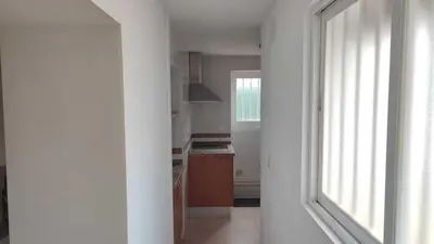 an empty kitchen with a window in a white room at Penthouse in the center in Cádiz
