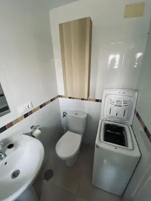 a white bathroom with a sink and a toilet at Penthouse in the center in Cádiz
