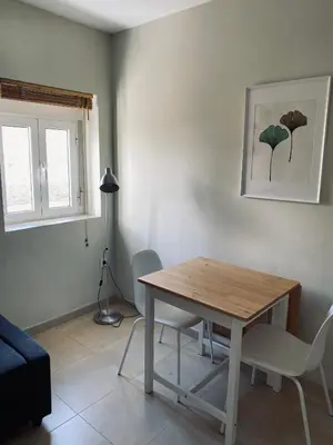 a living room with a wooden table and chairs at Penthouse in the center in Cádiz
