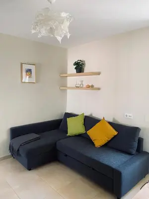 a blue couch with two yellow pillows in a room at Penthouse in the center in Cádiz