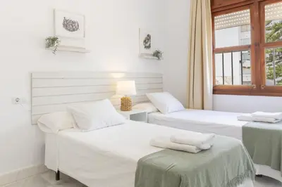a room with two beds and a window at Apartamento coqueto en la Playa de Regla. 4. in Chipiona