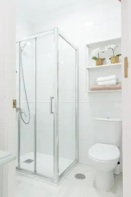 a white bathroom with a shower with a toilet at Apartamento coqueto en la Playa de Regla. 4. in Chipiona