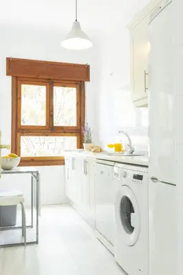 a white kitchen with a washing machine and a window at Apartamento coqueto en la Playa de Regla. 4. in Chipiona