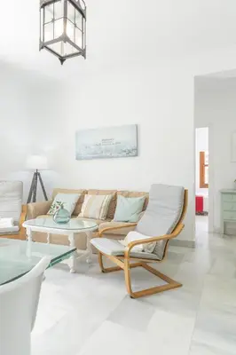 a living room with a couch and a table at Apartamento coqueto en la Playa de Regla. 4. in Chipiona