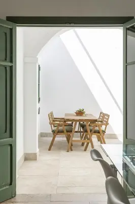 a dining room with a wooden table and chairs at Precioso apartamento con Chimenea patio solarium. in Chipiona