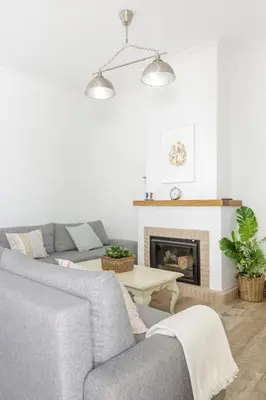 a living room with two couches and a fireplace at Precioso apartamento con Chimenea patio solarium. in Chipiona