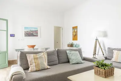 a living room with a gray couch and a table at Precioso apartamento con Chimenea patio solarium. in Chipiona