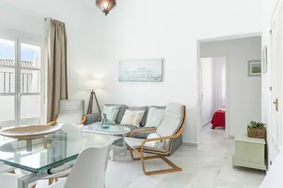 a living room with a couch and a glass table at Apartamento Playa de Regla con terraza. 1. in Chipiona