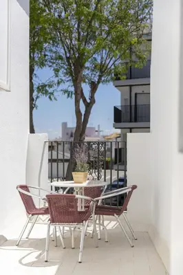 a table and chairs on a balcony with a tree at Apartamento Playa de Regla con terraza. 1. in Chipiona