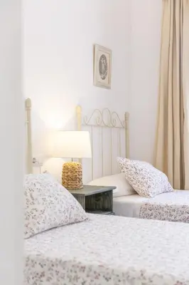 a bedroom with two beds and a table with a lamp at Luminoso y amplio piso en Chipiona. 5. in Chipiona