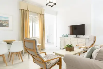 a living room with a couch and a tv at Luminoso y amplio piso en Chipiona. 5. in Chipiona